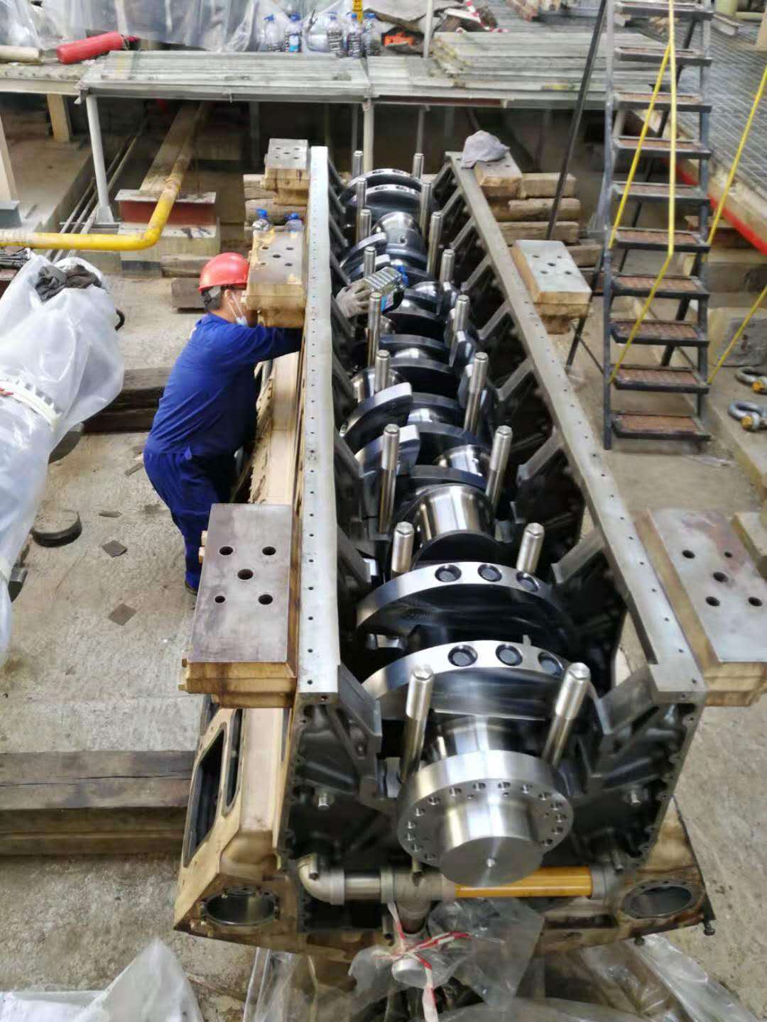 Engineers inspecting a large crankshaft rotor