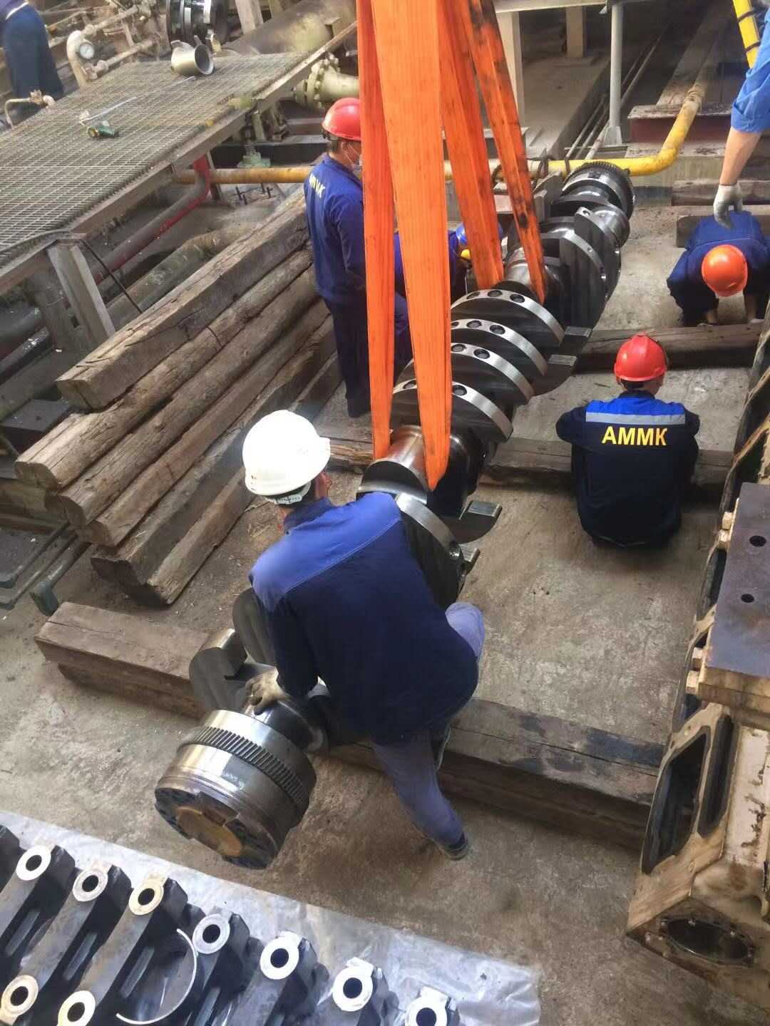 Team hoisting a crankshaft