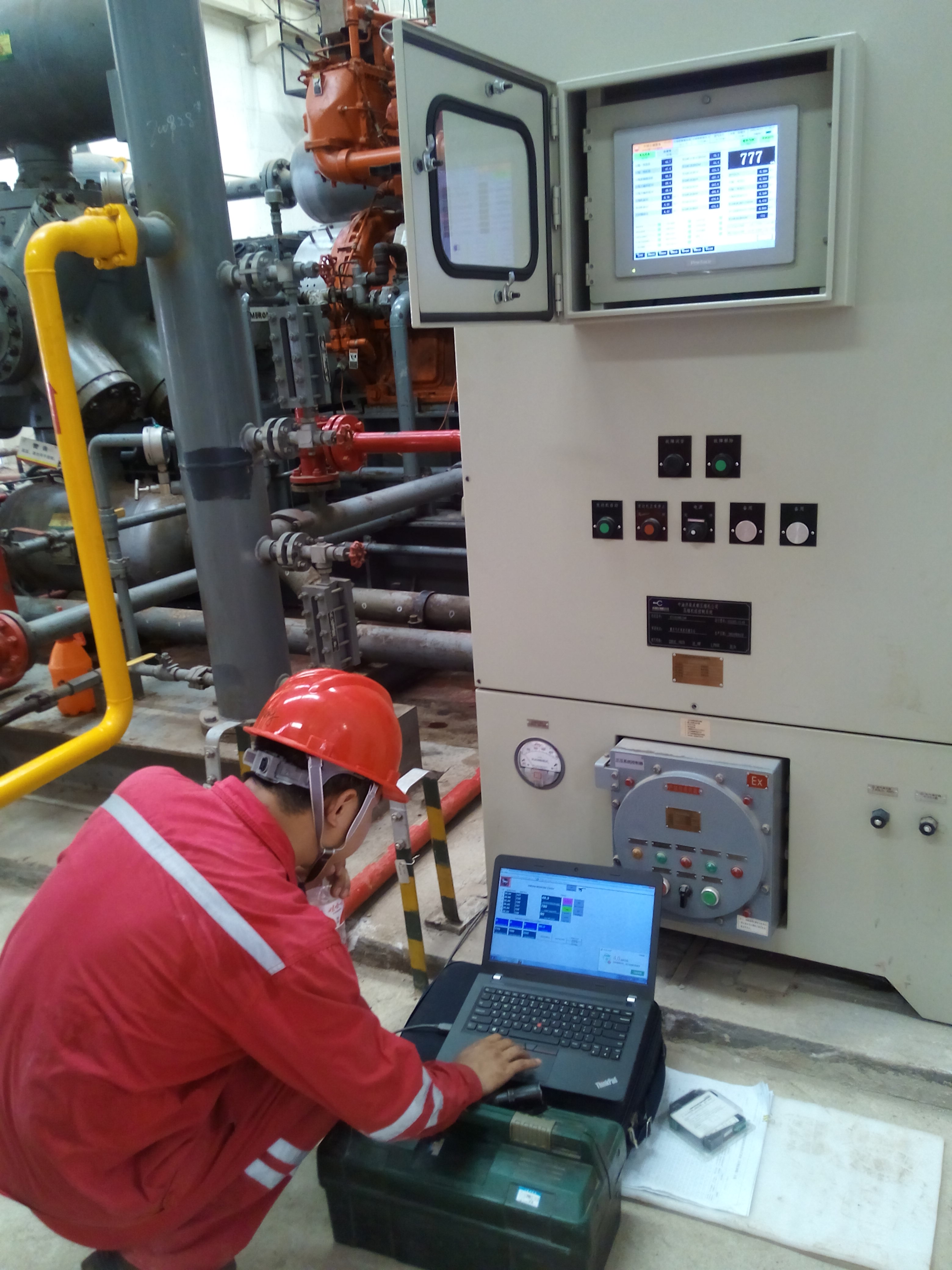 Engineer debugging control system with laptop